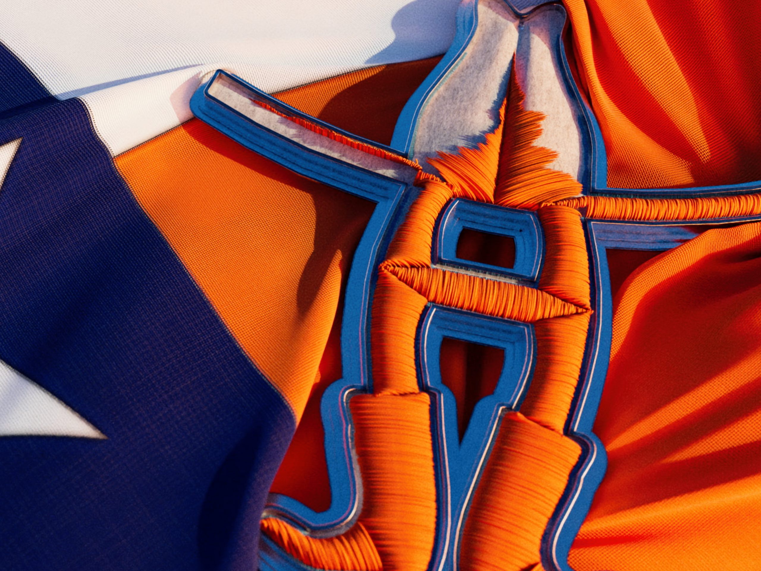 3D animation of intricate embroidery showcasing Houston Livestock Show & Rodeo's logo on a blue, white, and orange flag with a white star.