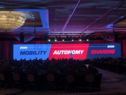 Speaker presents a timeline from 2020 to 2030 on mobility, autonomy, and sharing at a Gulf States Toyota event with a large LED screen and audience.