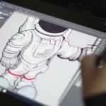 A hand drawing a detailed astronaut illustration on a digital tablet.
